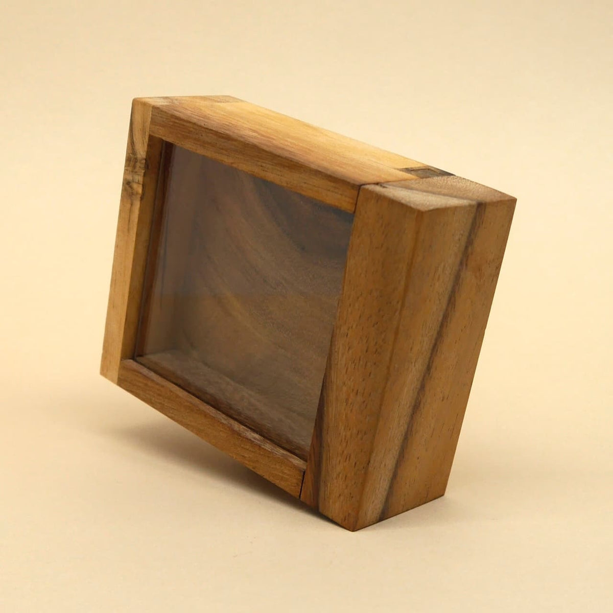 Aufrecht stehende Mystery‑Box aus glattem Holz mit Sichtfenster, vor neutralem Hintergrund abgelichtet.