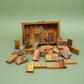 Buntes Doppel-9-Domino aus Holz, offen präsentiert mit herausgefallenen Steinen – ein beliebtes Familienspiel.
