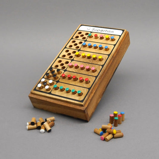 Aufrecht stehendes Superhirn Strategiespiel aus Holz – Reihen farbiger Stifte gesteckt, weitere Stifte liegen davor.